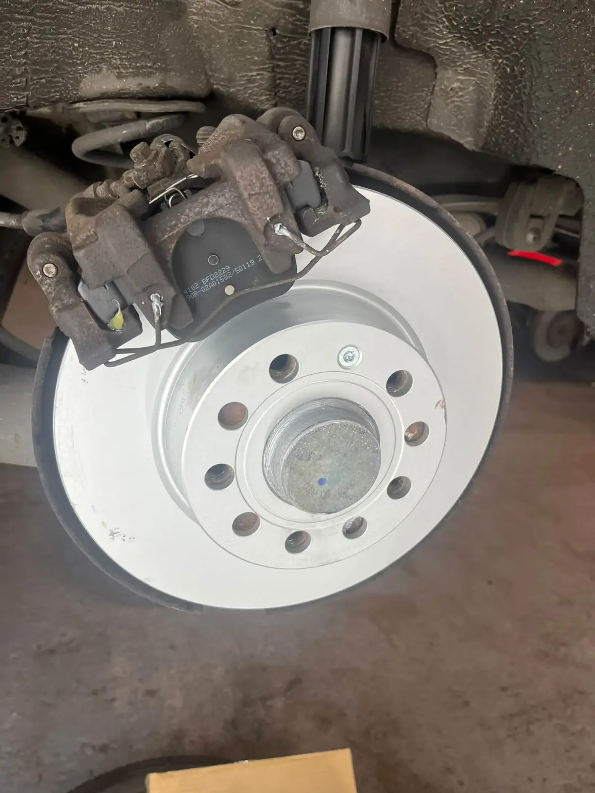 A new brake disc fitted with the caliper and pads in place